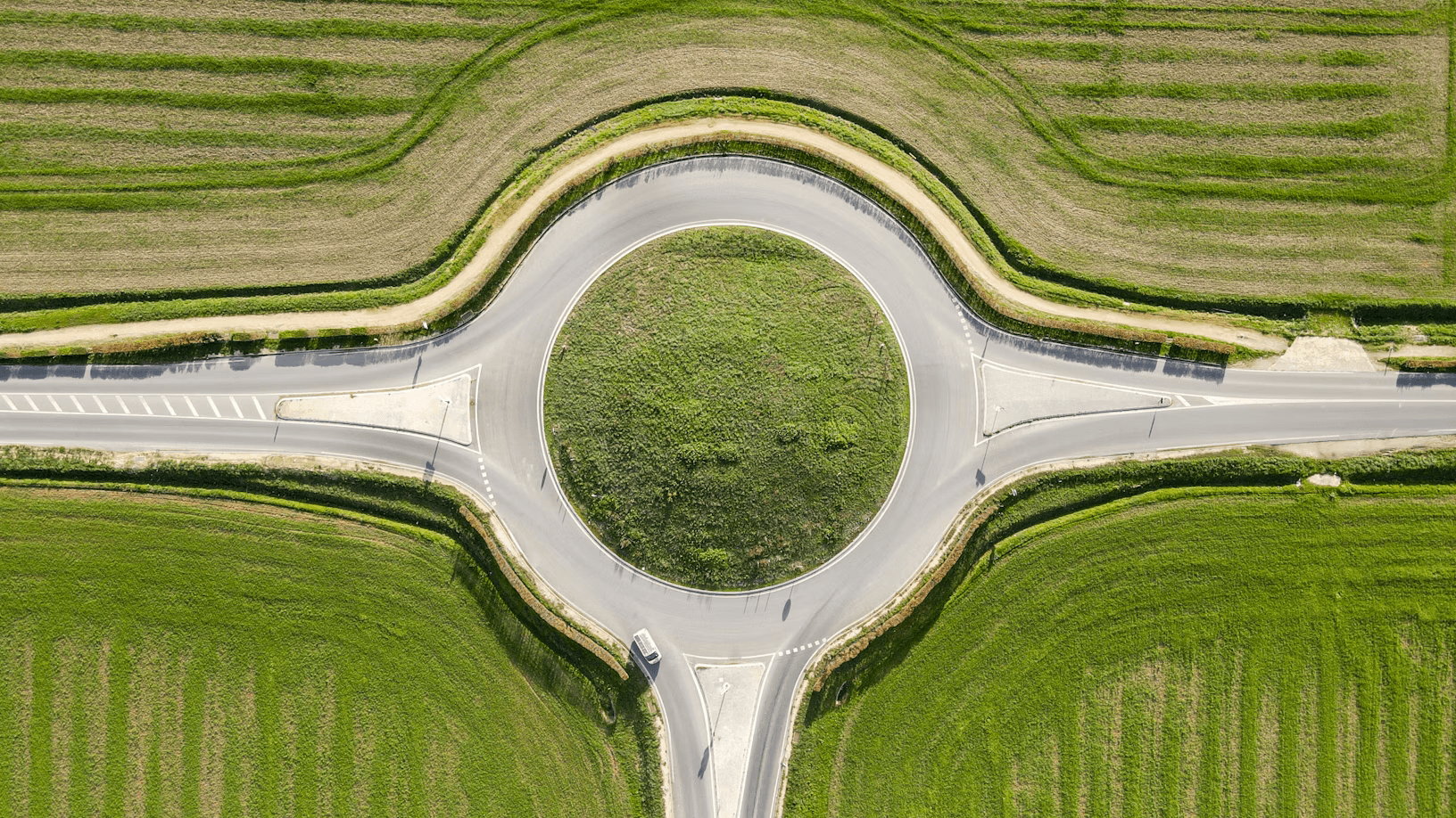 Aerial view of roundabout intersection in green fields